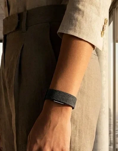 Knit wellness band worn on the wrist with relaxed linen clothing